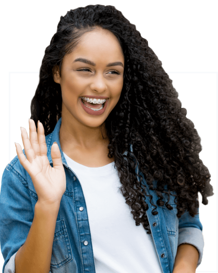 Girl with curls waving to the public, and smiling while undergoing orthodontic treatment (braces).