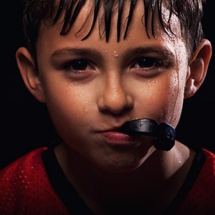 A young boy holding his mouth guard.