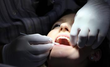 an orthodontist checking the denture of the patient.