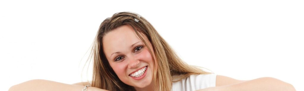 Young blonde woman smiling.