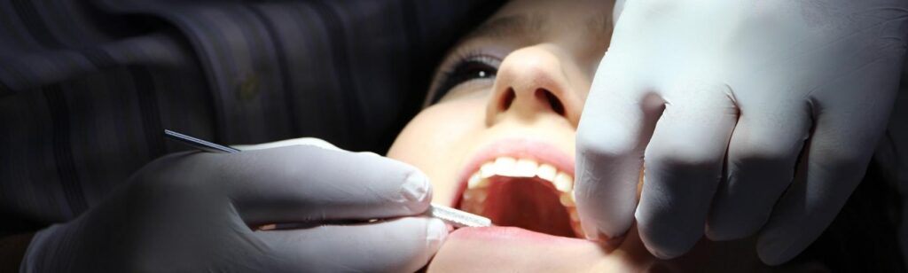 an orthodontist checking the denture of the patient.