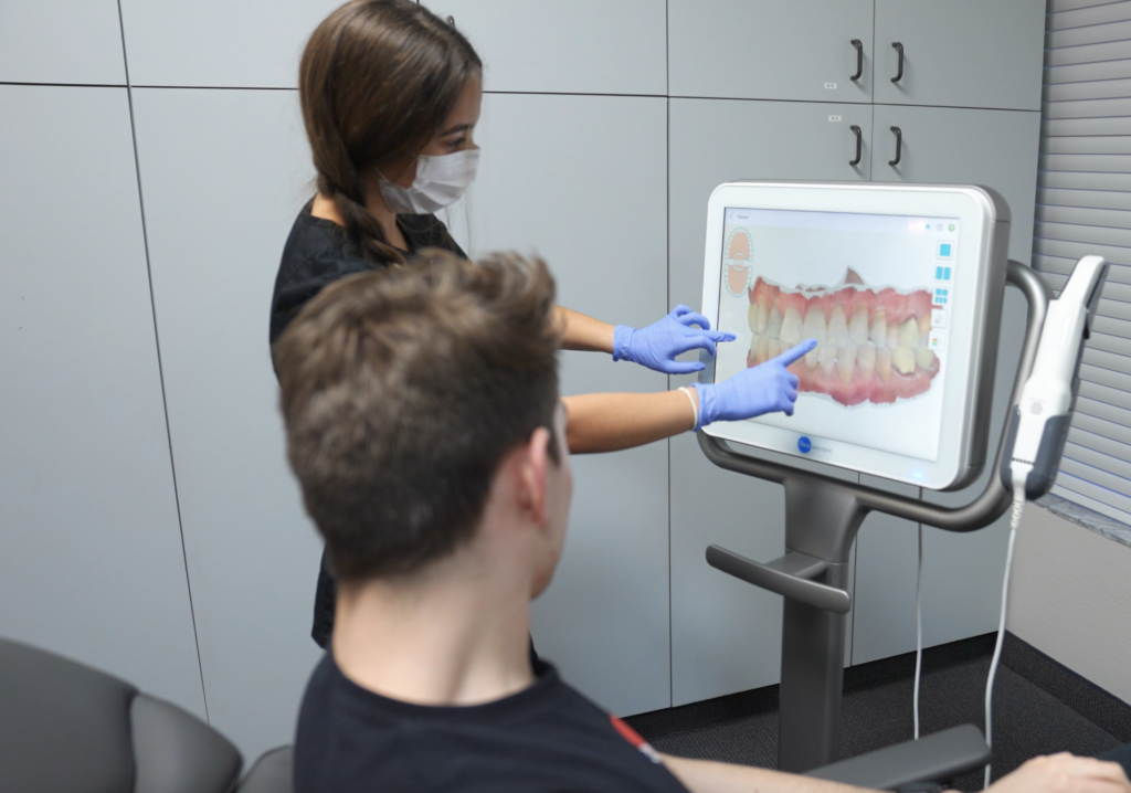 girl showing patient teeth on itero digital imaging machine