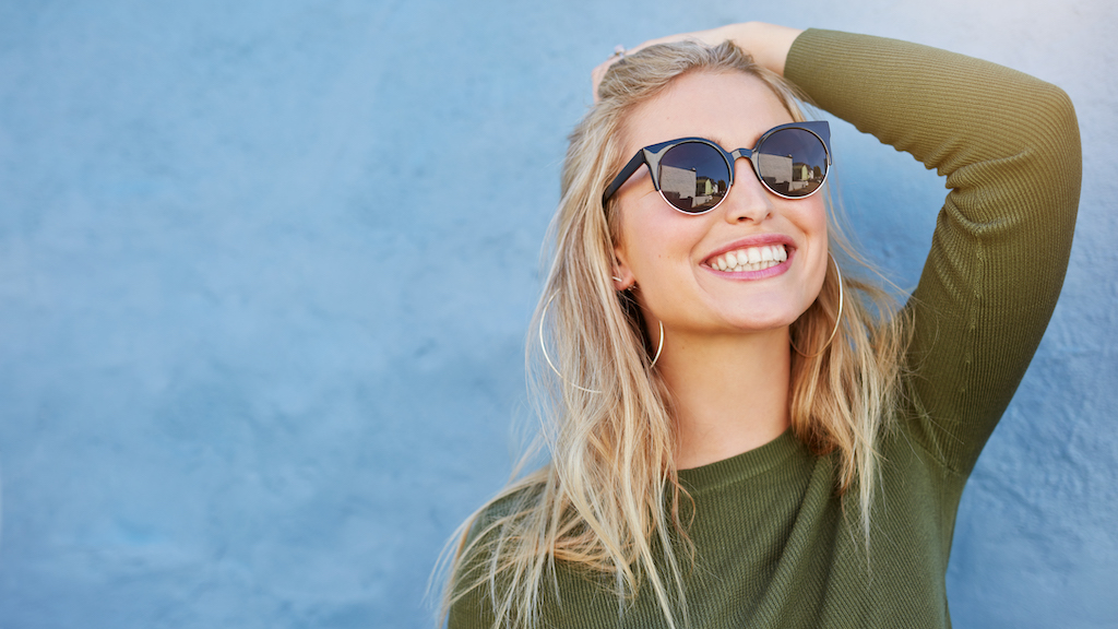 Stylish young woman in sunglasses smiling