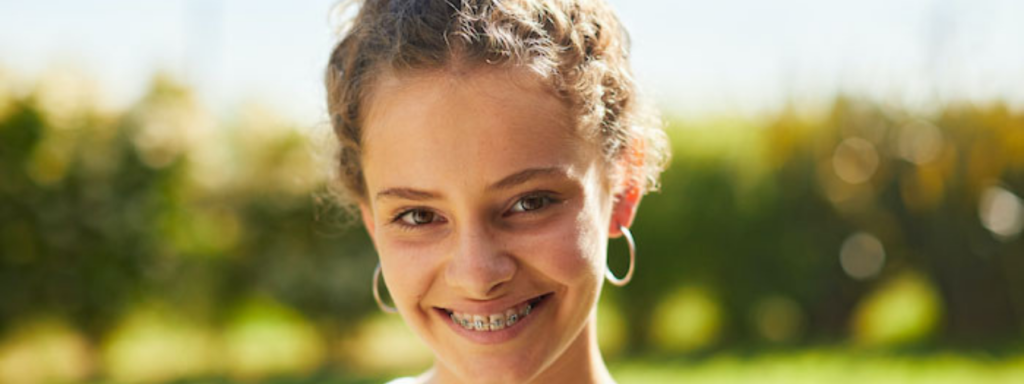 Teenager outdoors smiling at camera.