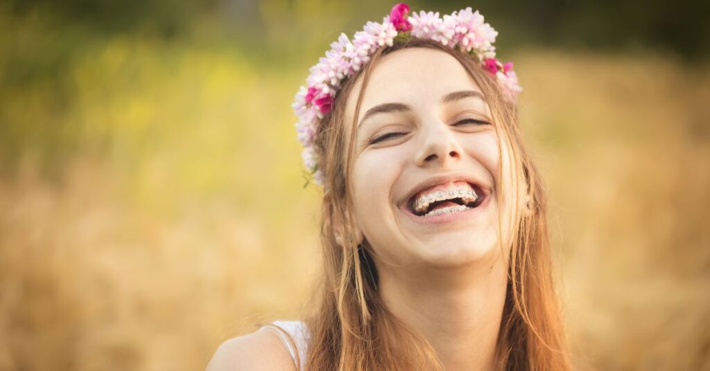 teen with braces in a field after her dental cleanings with braces
